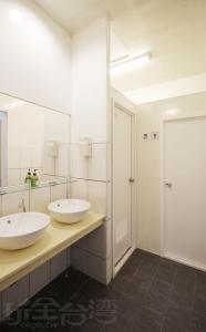 a bathroom with two sinks and a mirror at Sun Moon Lake Backpacker Hostel in Yuchi