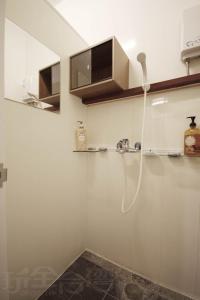 a white kitchen with a shower and a sink at Sun Moon Lake Backpacker Hostel in Yuchi