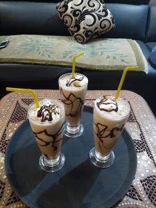 tres bebidas en una bandeja de vidrio en una mesa en Durbar Home Stay, en Pātan