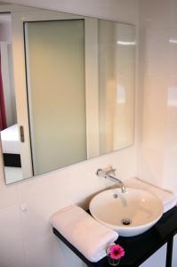 bagno con lavandino e specchio di V Hotel Kuala Lumpur a Kuala Lumpur