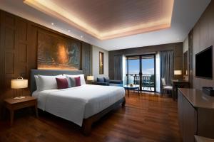 a bedroom with a large bed and a living room at Amari Vogue Krabi in Tab Kaek Beach