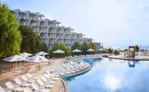 a hotel with a swimming pool with chairs and umbrellas at Laguna Beach Hotel in Albena