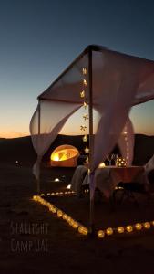 a tent with lights in the desert at night at STARLIGHT CAMP in Dubai