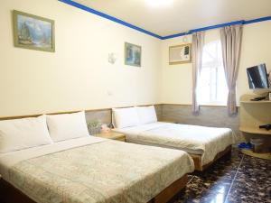 Postel nebo postele na pokoji v ubytování Fulong Haido Inn