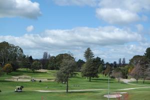 a park with green grass and trees on a cloudy day at St Andrews House in Hamilton