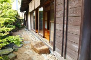 uma casa com um banco de pedra ao lado de um edifício em 藤花楼 KAMAKURA em Yamanouchi