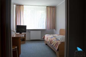 pokój hotelowy z łóżkiem, biurkiem i oknem w obiekcie Na Skarpie w Olsztynie