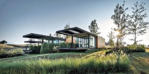 a house in the countryside with glass windows at De Capoc Resort in Khao Kho