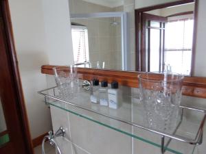 a bathroom with two sinks and a mirror at Berg en Zee Guesthouse in Gordonʼs Bay