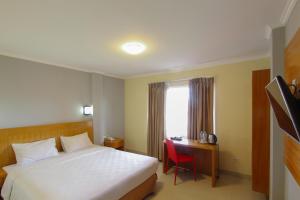 En eller flere senger på et rom på Maleosan Inn Manado Hotel