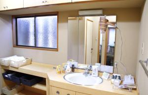 W łazience znajduje się umywalka i lustro. w obiekcie 藤花楼 KAMAKURA w mieście Yamanouchi