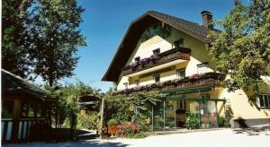 a large yellow house with flowers on the balcony at Gasthof Zur Seeburg in Seekirchen am Wallersee