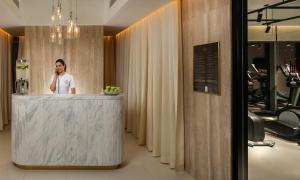 a man talking on a cell phone at a reception desk at Millennium Atria Business Bay in Dubai