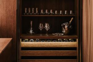 una credenza con bicchieri da vino e una brocca di champagne di New Luxury Lake view Apartment - Lausanne a Losanna