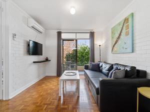 a living room with a couch and a table at Pronto Apartments in Perth