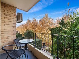 a balcony with two chairs and a table on it at Pronto Apartments in Perth