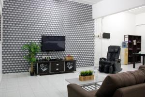 sala de estar con TV de pantalla plana en la pared en 39 Guest House, en Melaka