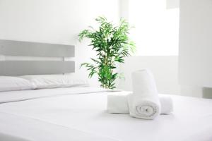 Una cama blanca con dos rollos de papel higiénico. en 39 Guest House, en Melaka