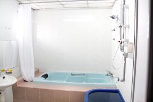 y baño con bañera azul y lavamanos. en 39 Guest House, en Melaka