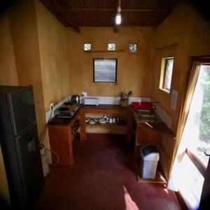 a kitchen with a desk and a sink in a room at Tree House Cottage, Ocean View in Praia do Tofo