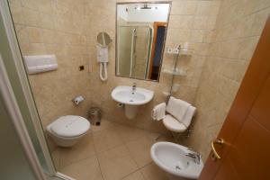 a bathroom with a sink and a toilet and a mirror at Hotel Portonuovo in Vieste