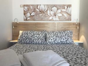 een slaapkamer met een bed met een schilderij aan de muur bij Belvedere Naxos 9 in Giardini Naxos