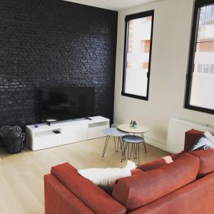 a living room with a red couch and a tv at Molenstraat in Dendermonde