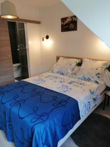 a bedroom with a bed with a blue blanket at Chambres d'Hôtes Chez Marilou in Aulnay-sous-Bois