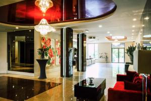 a lobby with a red couch and a table at Hotel Delicjusz in Trzebaw