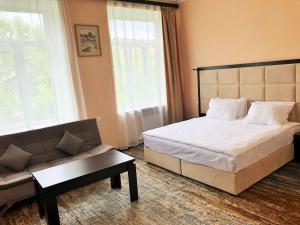 een slaapkamer met een bed en een bank bij Vanadzor Armenia Hotel in Vanadzor