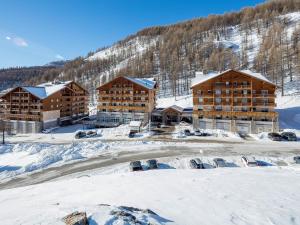 a ski lodge in the snow with cars parked in front at Noemys Terrasses de Labrau in La Foux