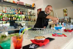 a man is making a drink at a bar at Hotel Portonuovo in Vieste
