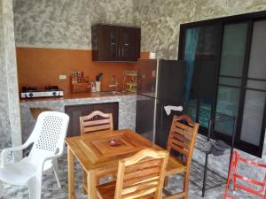 uma cozinha com uma mesa de madeira e cadeiras em Nananuira Apartment and Room em Khao Lak