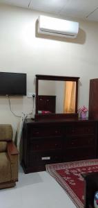 a living room with a dresser and a mirror at ROOMSTAY AQILAH PASIR PUTEH KELANTAN in Pasir Puteh +28 photos