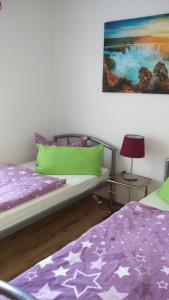 a bedroom with two beds and a painting on the wall at Gästehaus am Teich in Raben Steinfeld