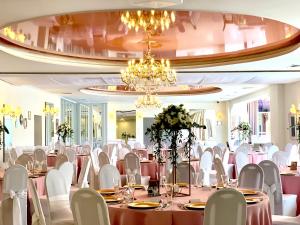 sala bankietowa ze stołami i krzesłami oraz żyrandolem w obiekcie Hotel Delicjusz w mieście Trzebaw