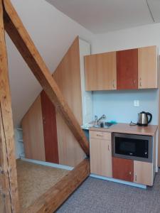 Kuchnia na poddaszu z drewnianymi szafkami i zlewem w obiekcie Apartmány F-M we Frydku-Mistku +16 zdjęć