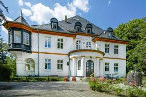 een groot wit huis met een zwart dak bij Villa Parkhaus in Wernigerode