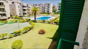 an apartment with a yard with a swimming pool at Viñas by Villas Rinamar in Playa de las Americas