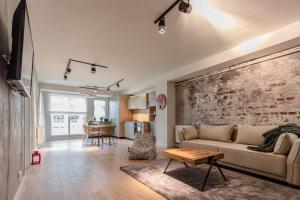 a living room with a couch and a brick wall at Ares ApartHotel in Cluj-Napoca