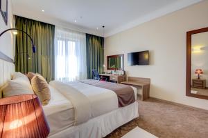 a hotel room with a bed and a desk at Garden Hotel & SPA in Bishkek