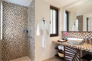 
a bathroom with a shower, sink, and mirror at Anantara Hoi An Resort in Hoi An
