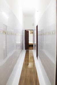 a hallway with white walls and a wooden door at Saigon City Center Hostel in Ho Chi Minh City
