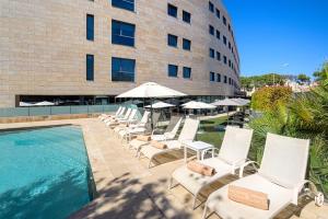 une rangée de chaises longues à côté d'un bâtiment dans l'établissement Hotel Maydrit Airport, à Madrid