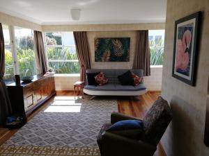 a living room with a couch and some windows at Super Central Cosy Greytown House with Garage in Greytown