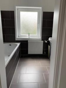 a bathroom with a bath tub and a window at Ferienwohnung Central No.1 in Bad Wildungen