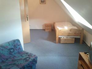 Pokój z łóżkiem i krzesłem na poddaszu w obiekcie Apartment Klara w Rokitnicach nad Izerą