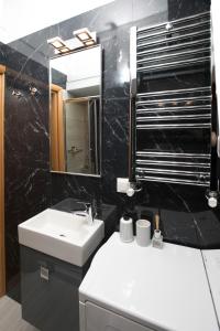 ein Badezimmer mit einem weißen Waschbecken und einem Spiegel in der Unterkunft Reindeer Apartment in Thessaloniki