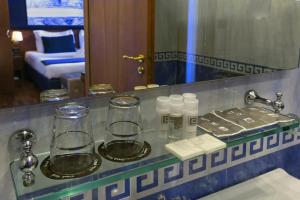 a bathroom counter with two glasses and a mirror at Grand Hotel Tiberio in Rome