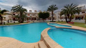 uma grande piscina em frente a um edifício em Townhouse Don Pueblo Gran Alacant em Gran Alacant